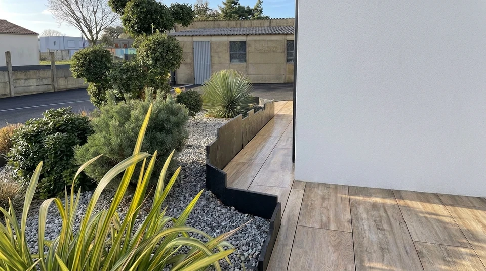 Jardin paysager extérieur avec allée courbe en dalles de grès rose disposées en quinconce sur pelouse verte entretenue